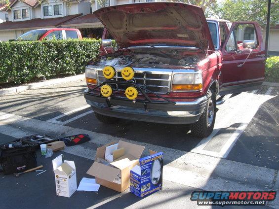 Red 1995 Ford F-150 with hood open, smiley face lights on a light bar, and tools on the ground