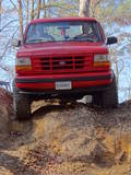 Red 1992 Ford Bronco front view climbing dirt hill