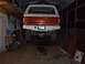 1989 Ford Bronco - The rear axle and bumper of a 1989 Ford Bronco are visible in this garage photo.