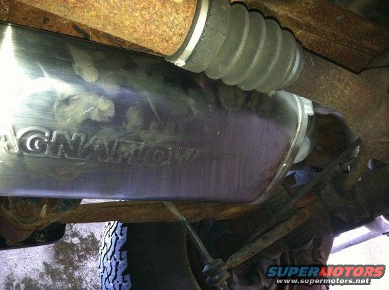 Magnaflow exhaust muffler with visible lettering, part of a vehicle's undercarriage
