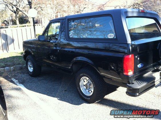 Black Ford Bronco parked outdoors, side view, with aftermarket wheels and tires