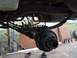 1989 Ford Bronco - Close-up view of a vehicle's rear axle assembly, showing suspension components and brake drum.