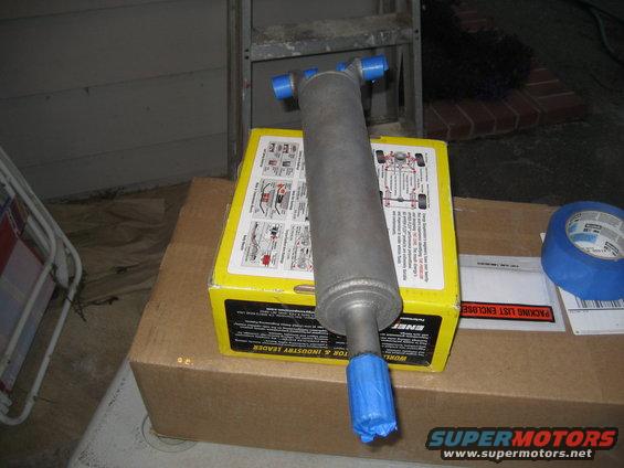 Shock absorber on top of a yellow box with diagrams, blue tape nearby