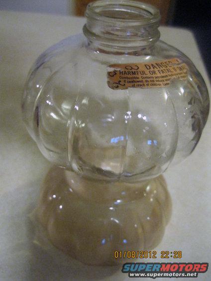 Glass bottle with a danger label, showing text about combustibility and harm
