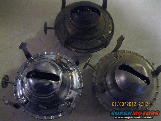 Three kerosene lamp burners, two shiny and one dark, on a surface. Date stamp 01/08/2012