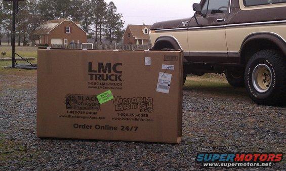 Ford Bronco parked next to a large LMC Truck parts box