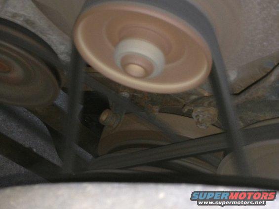 Engine belts and pulleys, some blurred from motion. Supermotors.net logo visible