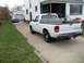 1970 Ford Ranchero - A white Ford pickup truck is parked in a driveway next to a house, with another vehicle visible in the background.