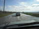 1993 Ford Bronco - A white pickup truck navigates a flooded road, with another vehicle following behind.