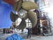 1993 Tracker Tournament - A worker stands next to a massive ship propeller undergoing maintenance in a dry dock.
