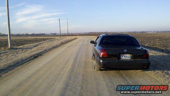 1999 Mercury Grand Marquis parked on a dirt road in a rural area
