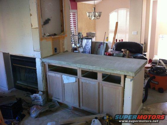 Kitchen island under construction with unfinished cabinets and countertop