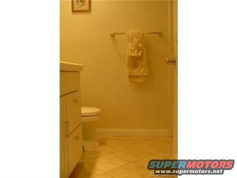 Bathroom with vanity, toilet, and towel rack