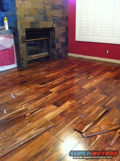 room with fireplace and red walls, new wood floor being installed