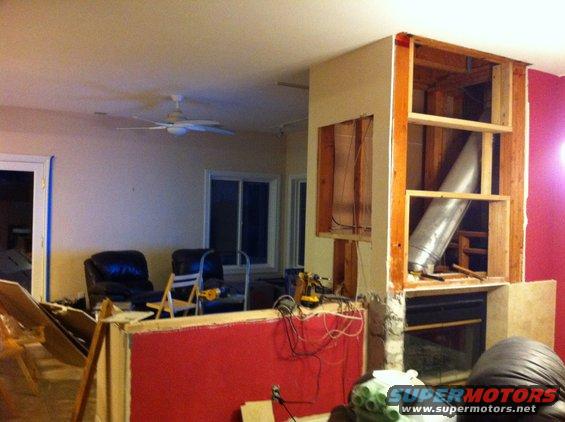 room under construction with exposed framing, ductwork, and fireplace