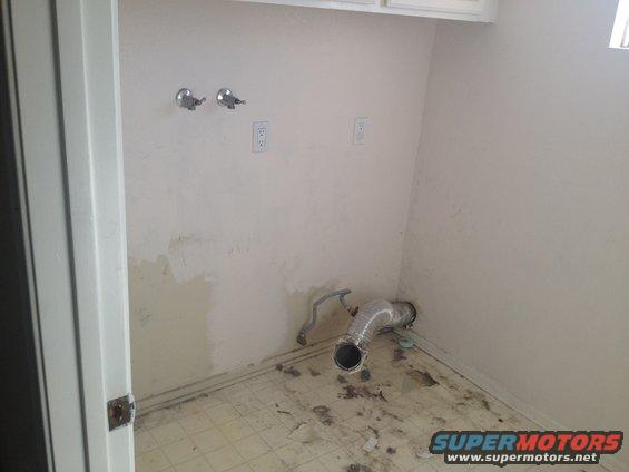 empty room with plumbing hookups and vent pipe on floor