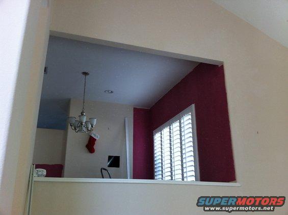 Interior view of a room with a chandelier, Christmas stocking, and window blinds