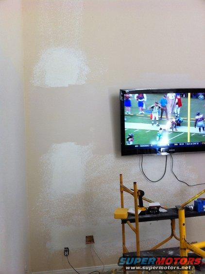 Scaffolding and TV displaying a football game