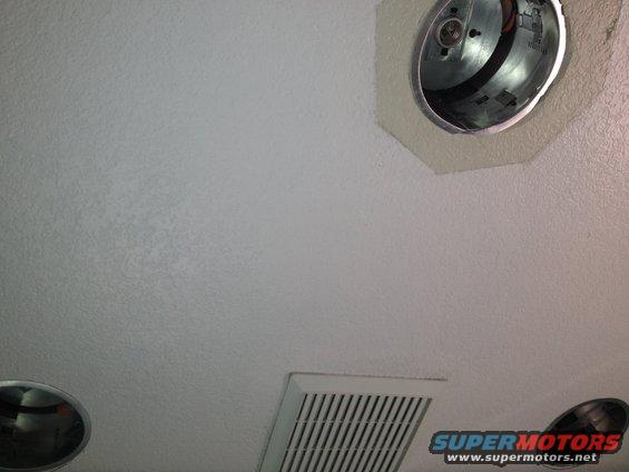 ceiling light fixture and air vent on textured ceiling, with SUPERMOTORS logo in corner
