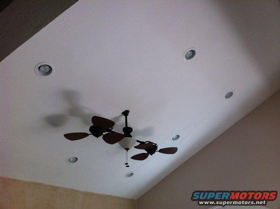 Ceiling with a dark wood ceiling fan and several recessed lights