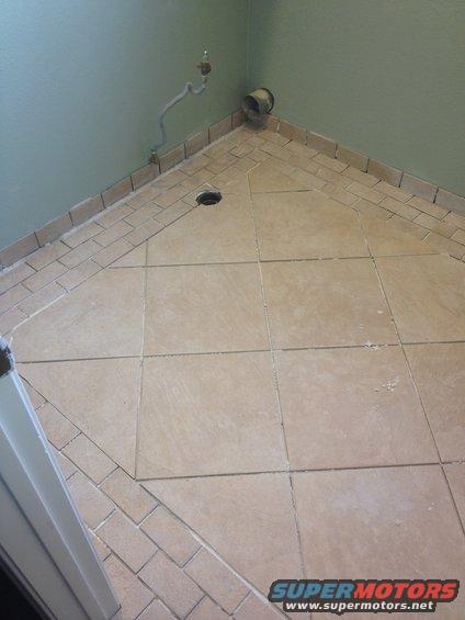 tiled corner with drain, pipe, and vent