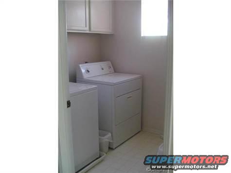 laundry room with white washer and dryer, cabinets above