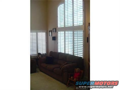 Interior room with large windows covered by plantation shutters and a sofa