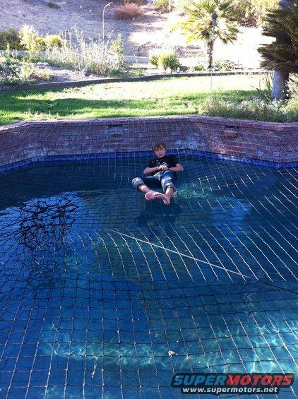 Boy sits on a pool safety net