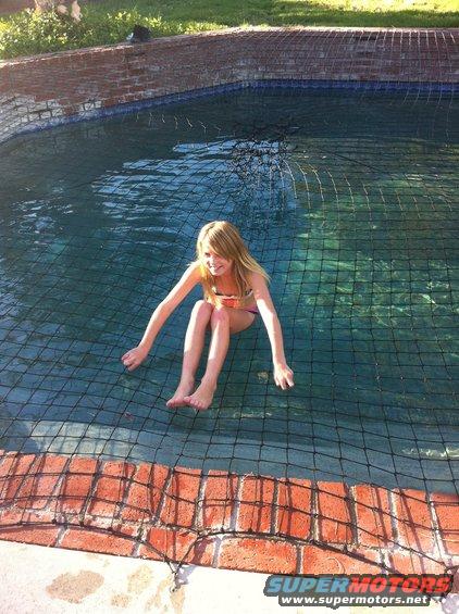Girl sitting in a pool covered by a net