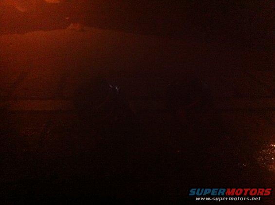 dark car interior, dashboard visible, some lights reflecting