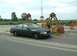 2003 Ford Crown Victoria - A black Ford Crown Victoria police car is parked outdoors near large industrial cranes.