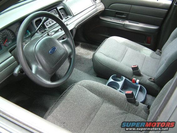 Interior shot of a 2003 Ford Crown Victoria, showing the steering wheel, dashboard, and front seats