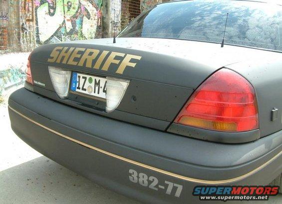 Dark gray 2003 Ford Crown Victoria Police Interceptor rear with gold "SHERIFF" text and license plate IZ-M-4