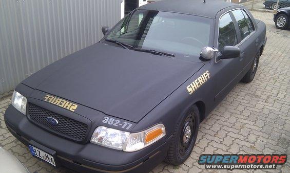 Black 2003 Ford Crown Victoria sheriff car with gold lettering on hood and door