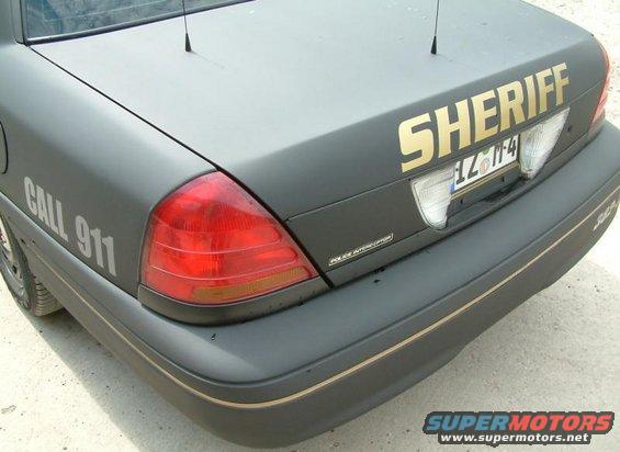 Dark gray 2003 Ford Crown Victoria Police Interceptor rear with gold "SHERIFF" text and "CALL 911" on the side
