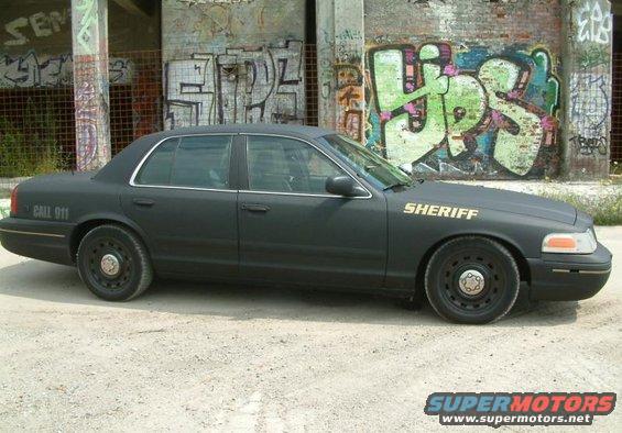 Black sheriff car side view with 'SHERIFF' text on hood