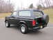 1996 Ford Bronco - This black Ford Bronco is shown from the rear three-quarter view, parked outdoors on a paved surface.