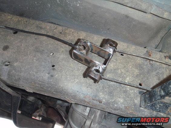 custom bracket holding brake cable on underside of vehicle frame