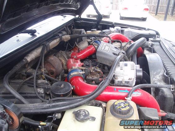 engine bay with red turbo pipes and a powerstroke turbo sticker