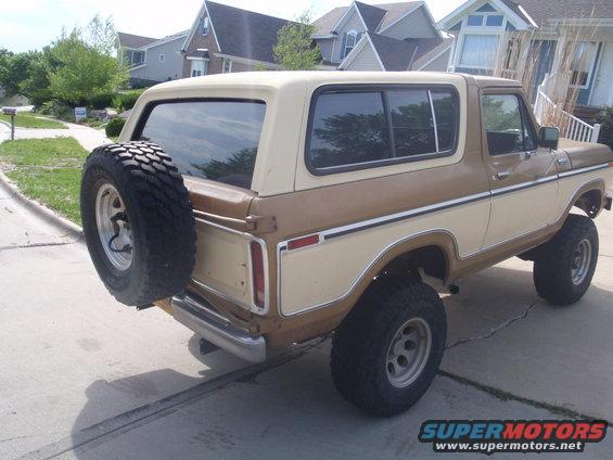 Rear view of a 1978 Ford Bronco with a two-tone brown and cream paint job and a spare tire on the tailgate
