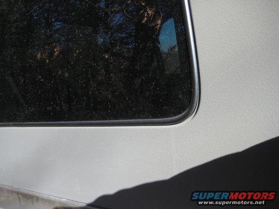 Gray vehicle side panel with a chrome-trimmed dark window; Supermotors.net watermark visible