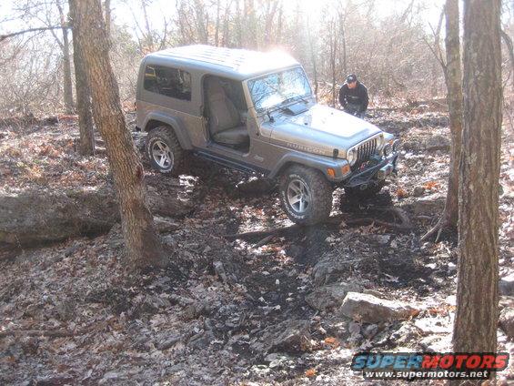 Gray 2005 Jeep Wrangler Rubicon off-roading on a rocky trail