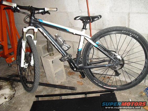 Mountain bike with white and blue accents, parked indoors