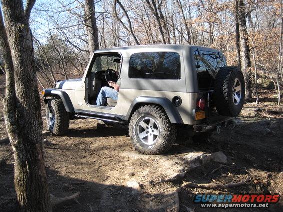 Tan 2005 Jeep Wrangler on rocky trail