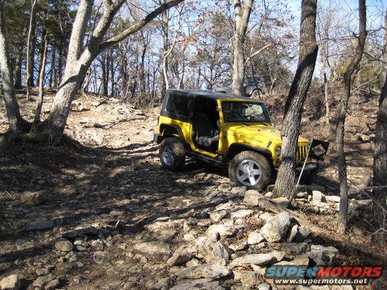 Yellow 2005 Jeep Wrangler Rubicon navigating a rocky off-road trail
