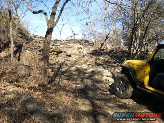Yellow Jeep Wrangler on rocky terrain, front-right quarter view