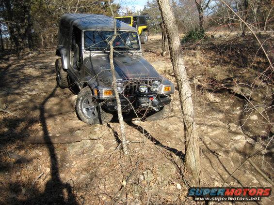 Silver Jeep Wrangler on rocky trail, yellow Jeep in background