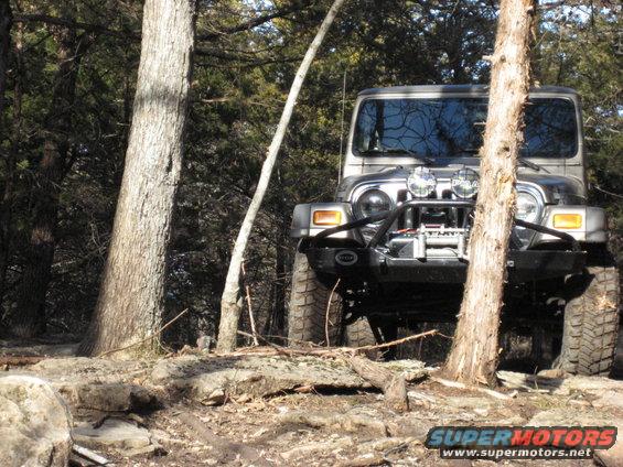 Jeep Wrangler on rocky trail, trees around