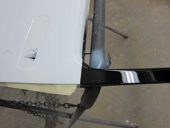 White door panel with black trim and a chain