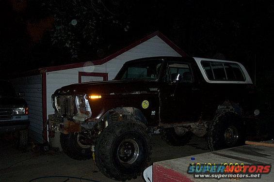 1978 Ford Bronco with a white top, parked next to a building. Another vehicle is partially visible on the left
